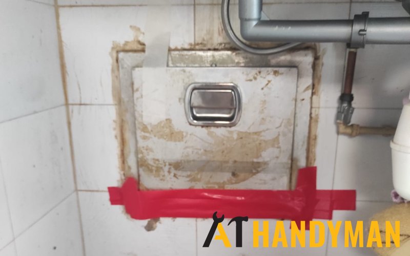 A broken bin chute hopper with a crude repair held together by red tape.