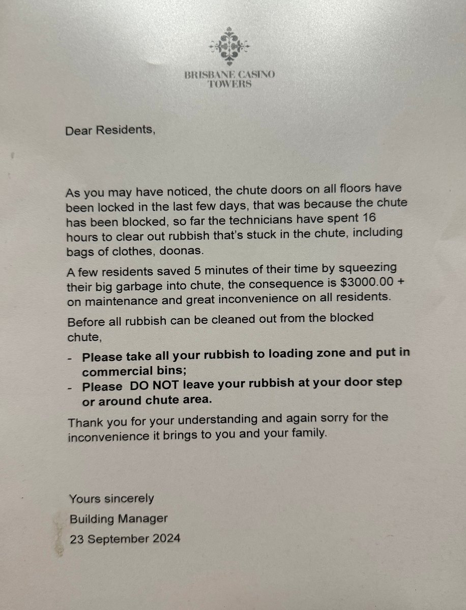 A notice posted in a residential lift explaining that the waste chute is blocked and asking residents to take rubbish to the ground floor.